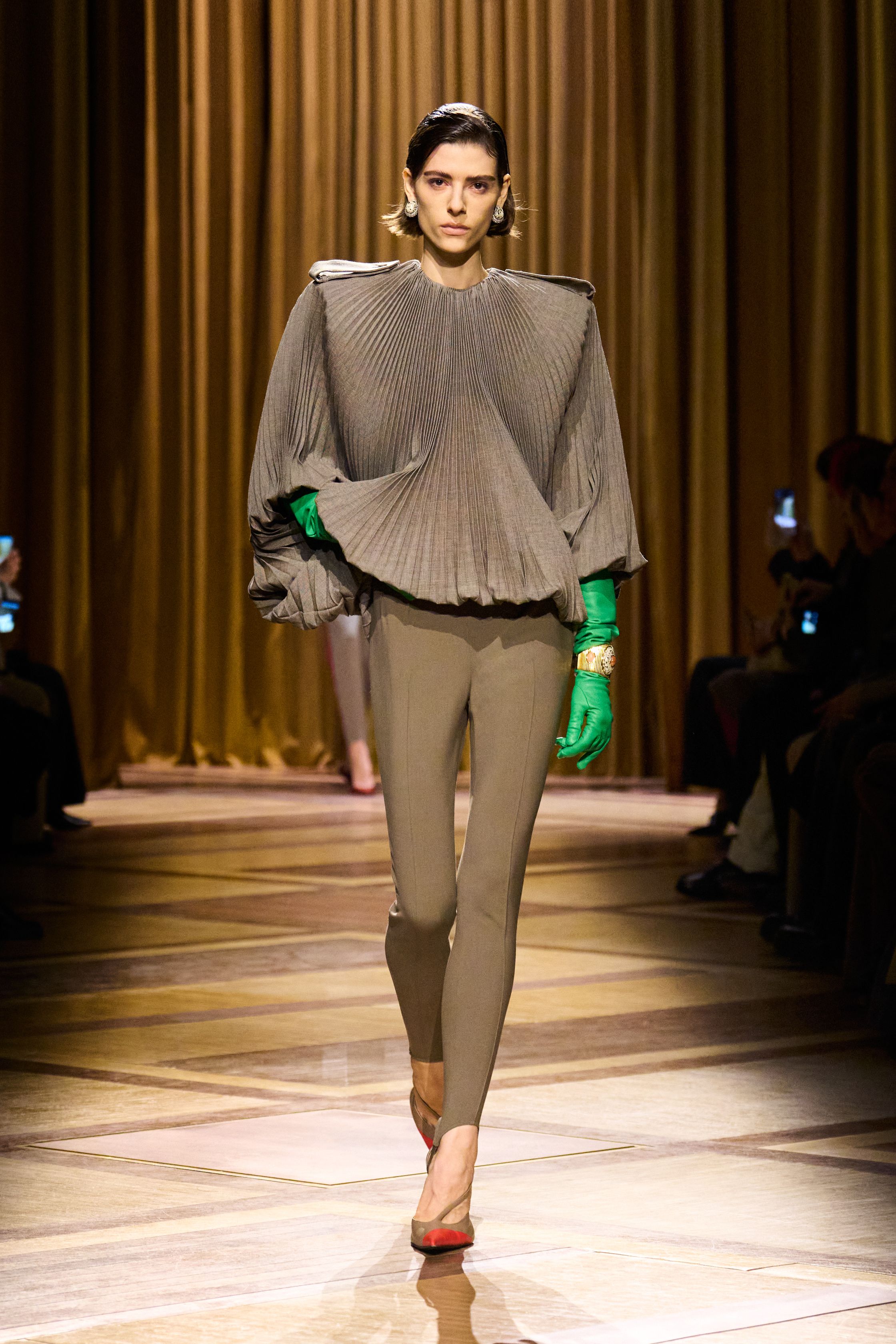 Mugler 本季继续强化品牌最核心的雕塑性感：极端肩线、收紧腰部与流畅长裤塑造出未来感女性轮廓。紫色权力套装、金属光泽衬衫和皮革裙装让整场秀既强势又华丽，仿佛科幻电影中的都市女主角-顽石频道趋势研究